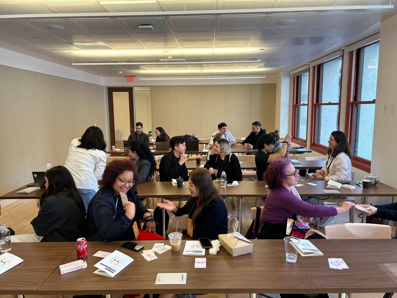 A room of people in pairs passing cards across the tables.